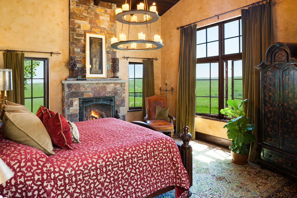 Inspiration for a southwestern master bedroom remodel in Other with orange walls, a standard fireplace and a stone fireplace