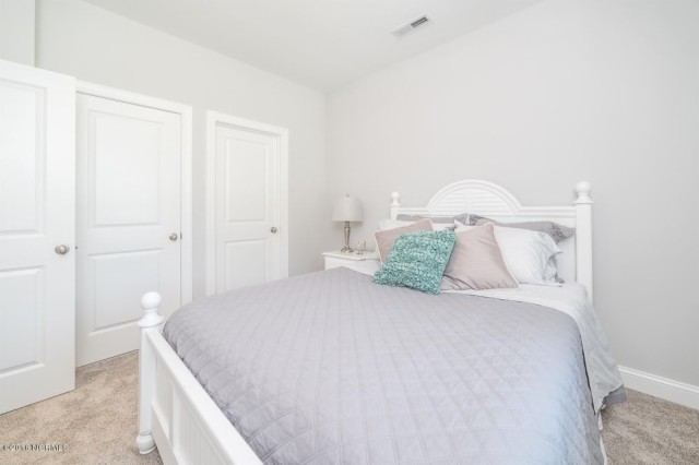 Diseño de habitación de invitados actual pequeña con paredes beige y moqueta