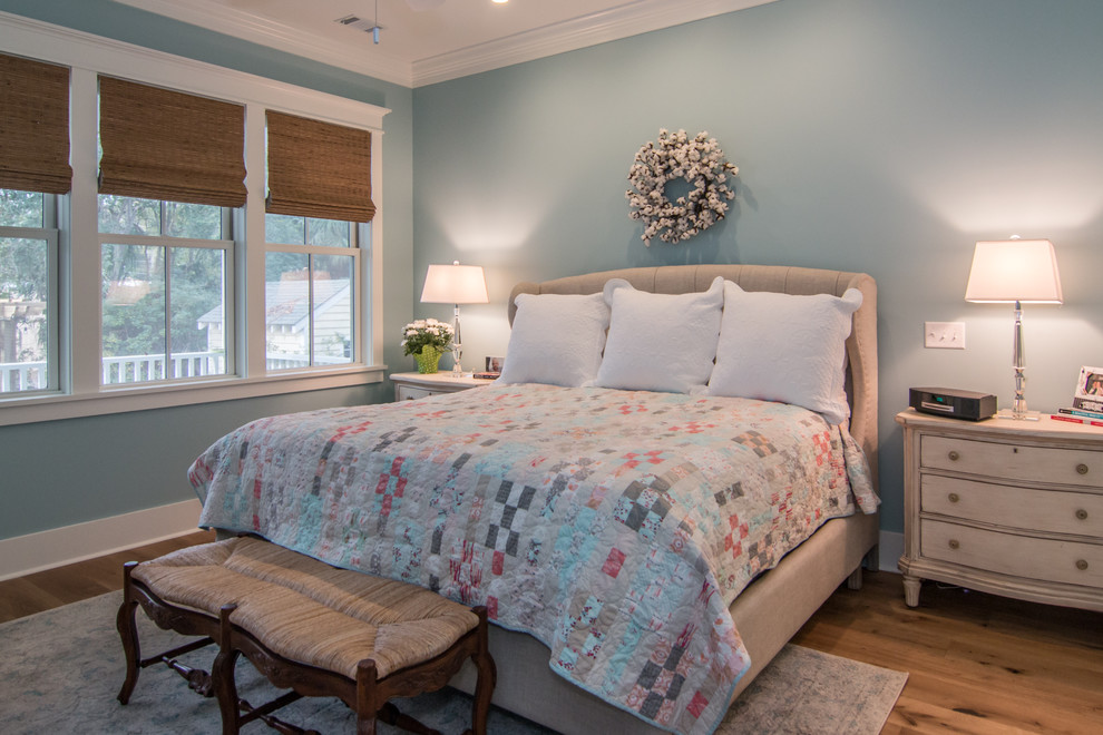 Modelo de dormitorio tradicional con paredes beige, suelo de madera clara y suelo beige