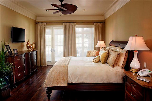 Aménagement d'une chambre parentale classique de taille moyenne avec un mur beige, parquet foncé et un sol marron.