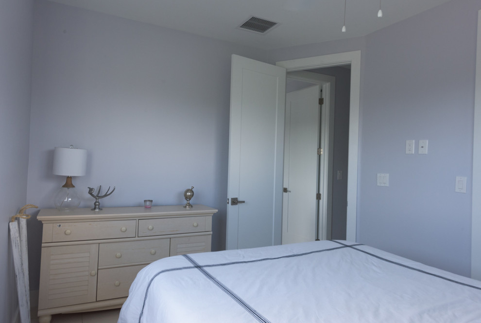 Foto di una piccola camera degli ospiti stile marinaro con pareti blu, pavimento con piastrelle in ceramica e nessun camino