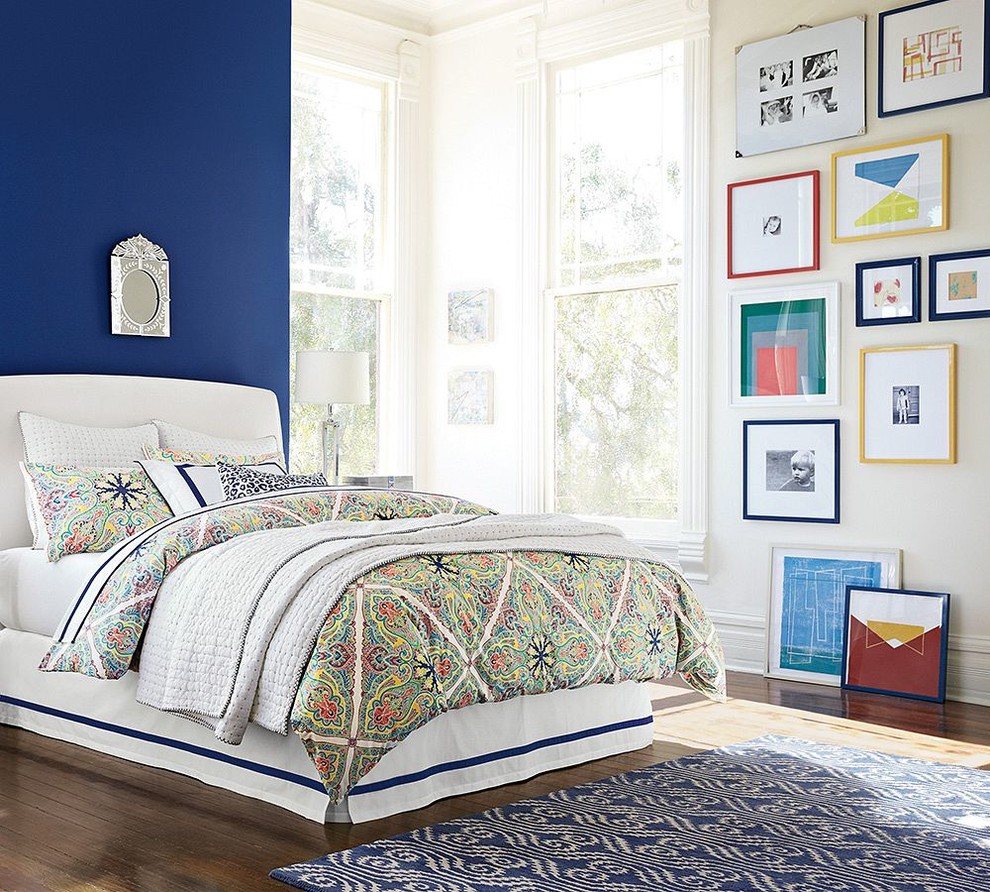 Eclectic master medium tone wood floor bedroom photo in Sacramento with blue walls