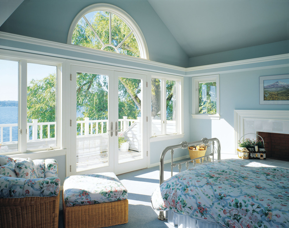 Foto de dormitorio principal tradicional con paredes azules, moqueta, todas las chimeneas y marco de chimenea de baldosas y/o azulejos