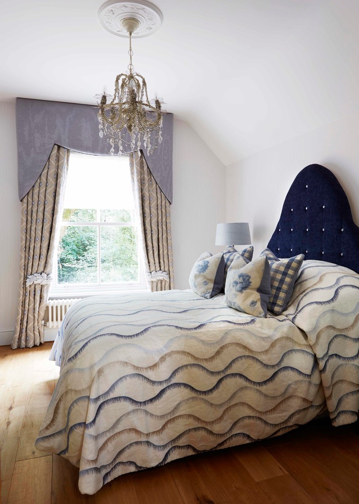 Großes Landhaus Gästezimmer mit blauer Wandfarbe und braunem Holzboden in Oxfordshire
