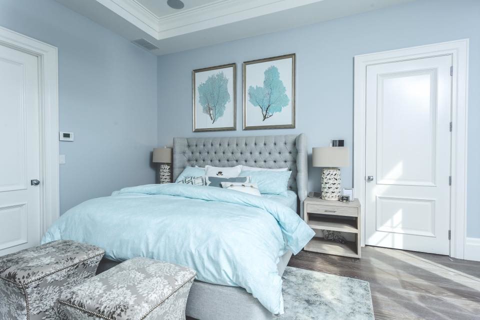 ニューヨークにある広いトランジショナルスタイルのおしゃれな主寝室 (青い壁、無垢フローリング、暖炉なし、茶色い床)
