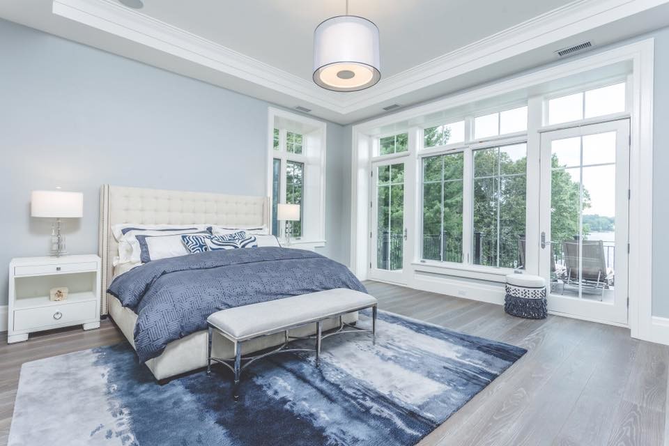 Идея дизайна: большая хозяйская спальня в стиле неоклассика (современная классика) с синими стенами, паркетным полом среднего тона и коричневым полом без камина