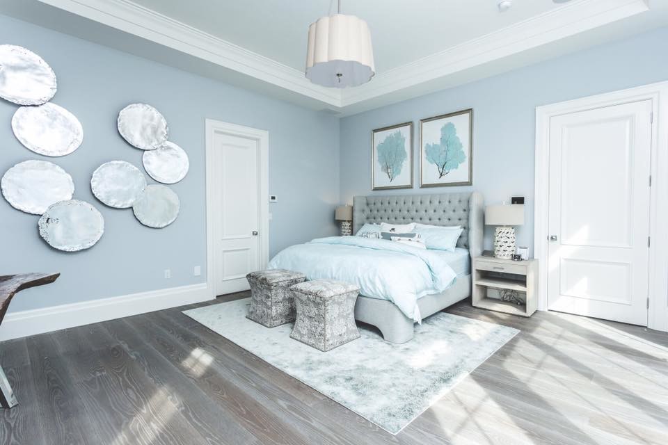 ニューヨークにある広いトランジショナルスタイルのおしゃれな主寝室 (青い壁、無垢フローリング、暖炉なし、茶色い床) のインテリア