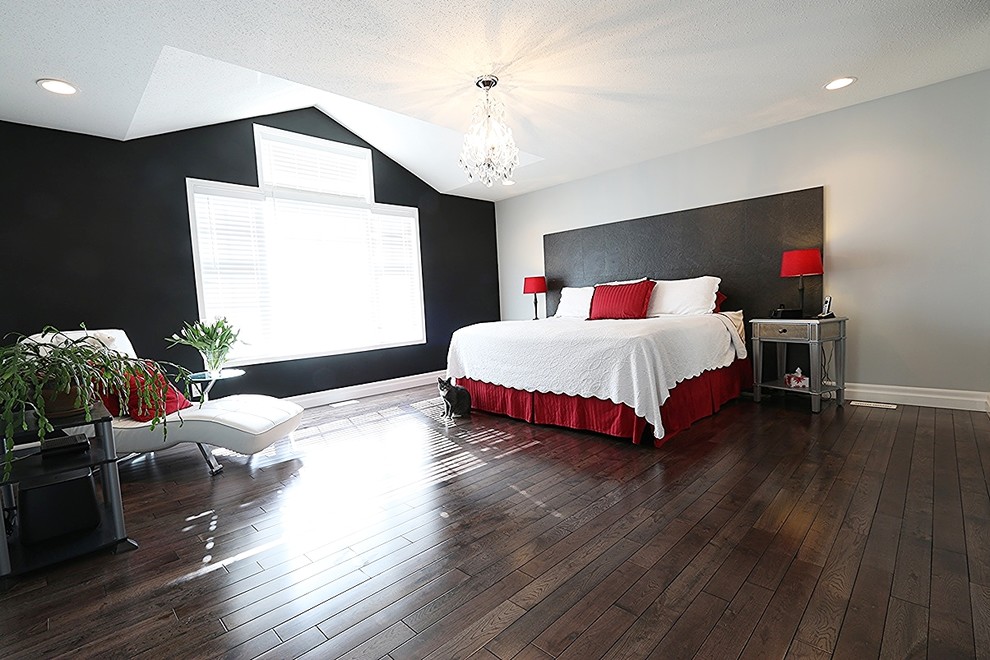Photo of a modern master bedroom in Ottawa with dark hardwood flooring, no fireplace and black walls.