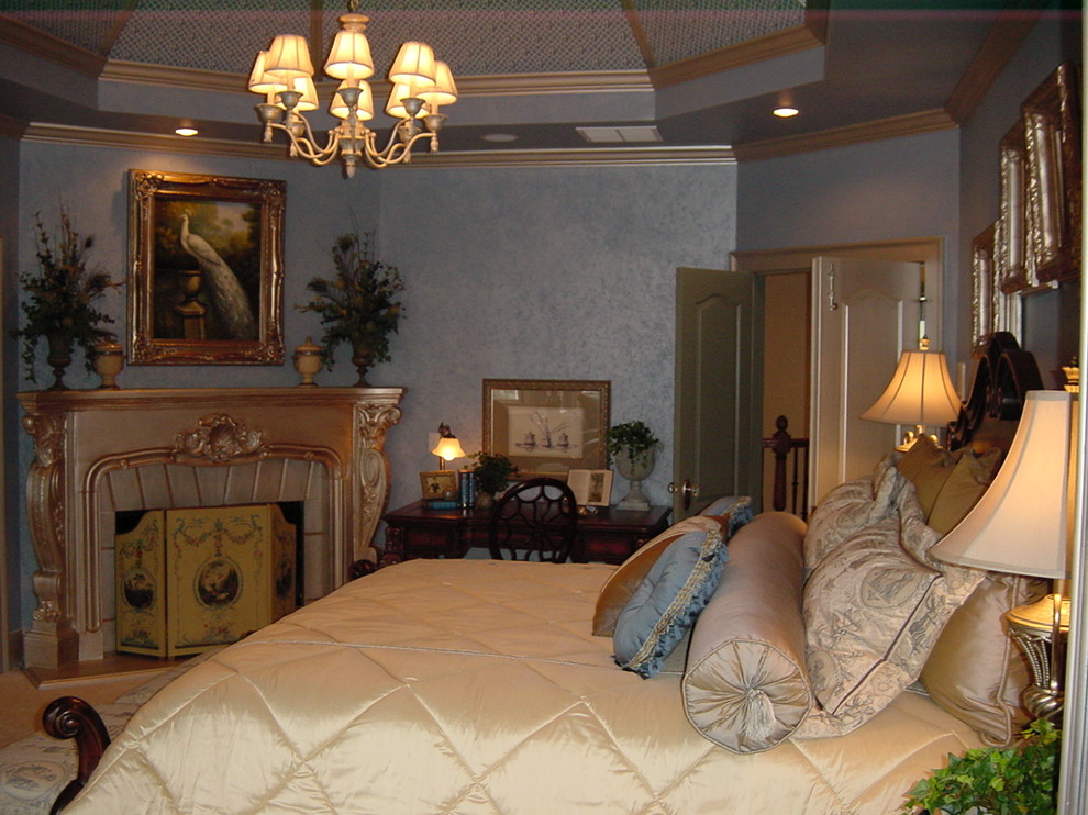 На фото: хозяйская спальня среднего размера в викторианском стиле с синими стенами, полом из травертина, стандартным камином и фасадом камина из камня