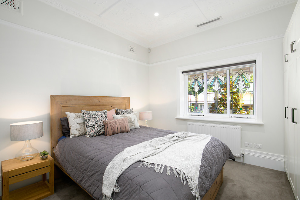 Imagen de habitación de invitados contemporánea sin chimenea con paredes blancas, moqueta y suelo gris