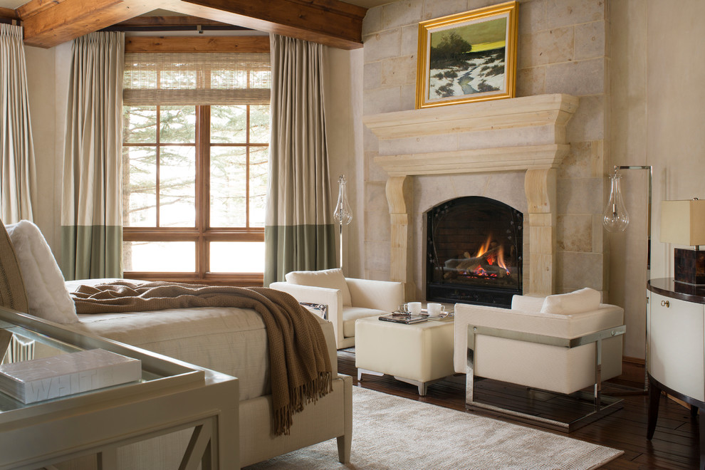 Aménagement d'une chambre parentale montagne avec un mur beige, parquet foncé, une cheminée standard et un manteau de cheminée en pierre.