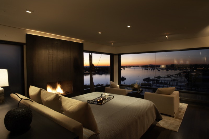 Immagine di una camera da letto minimal con parquet scuro e camino classico