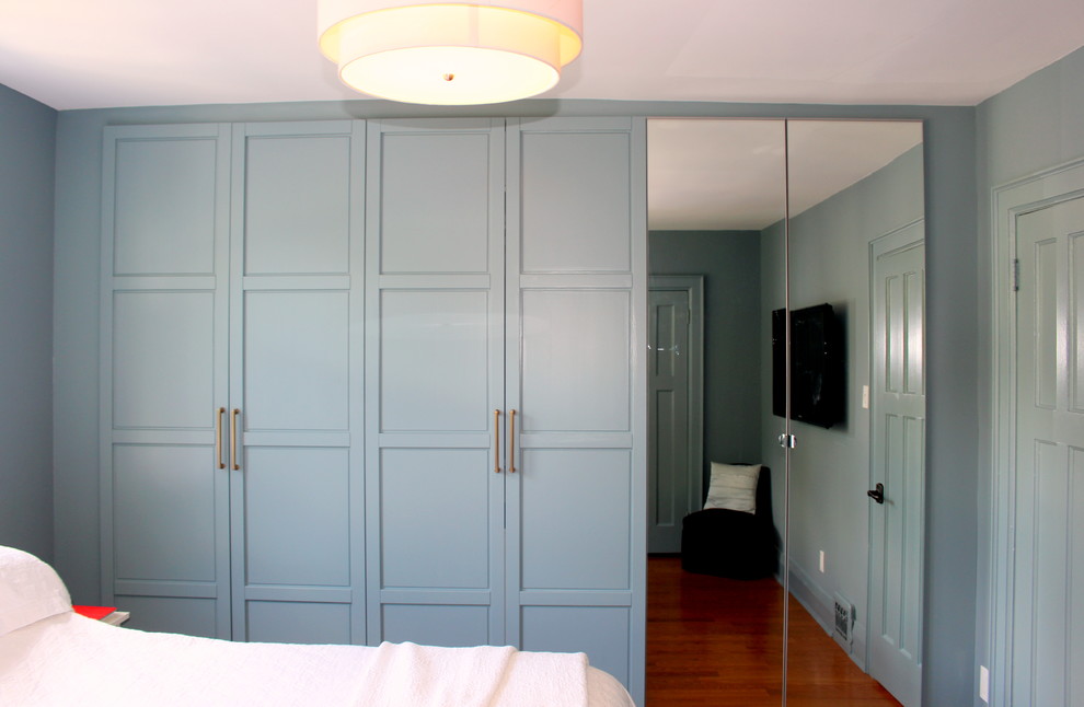Esempio di una piccola camera matrimoniale classica con pareti blu, pavimento in legno massello medio, nessun camino e pavimento marrone
