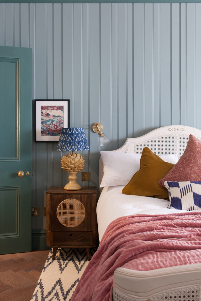 ロンドンにあるトランジショナルスタイルのおしゃれな寝室 (青い壁、無垢フローリング、茶色い床) のインテリア