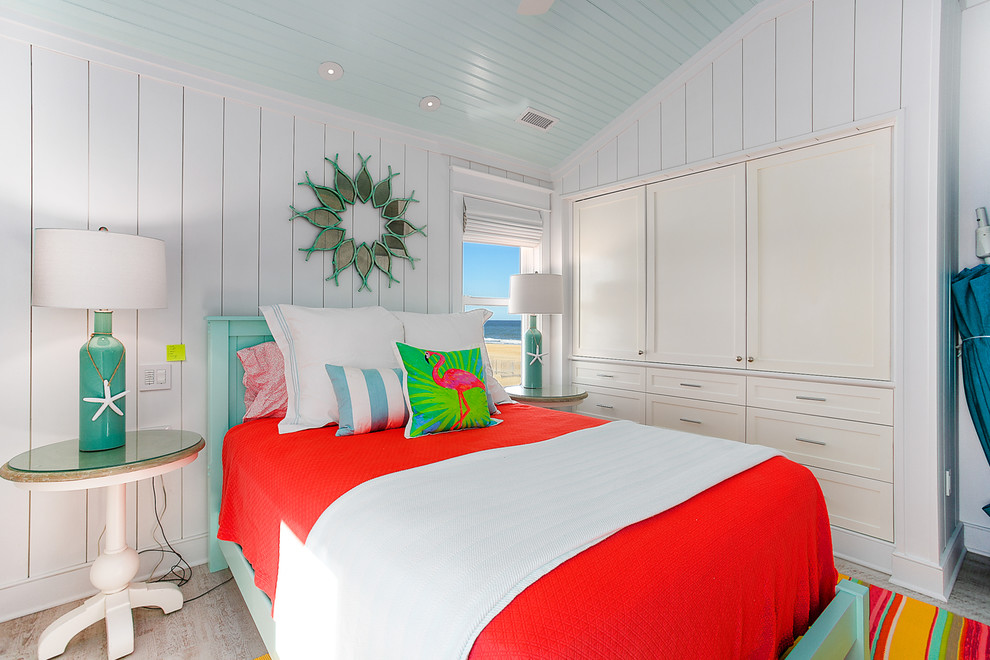 Imagen de habitación de invitados costera pequeña con paredes blancas y suelo vinílico