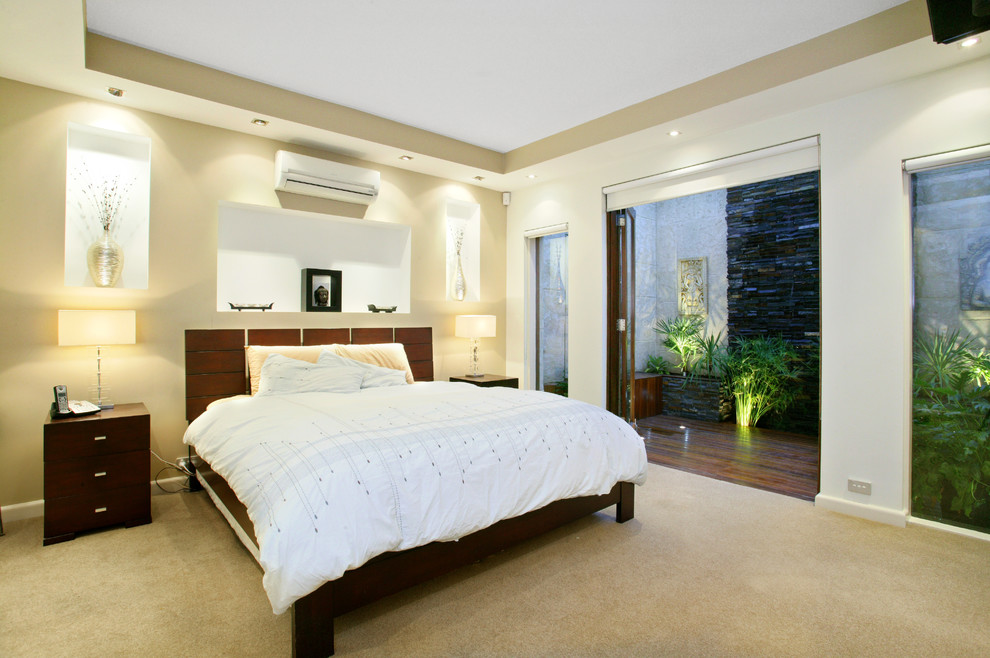 Пример оригинального дизайна: большая хозяйская спальня в современном стиле с бежевыми стенами и ковровым покрытием