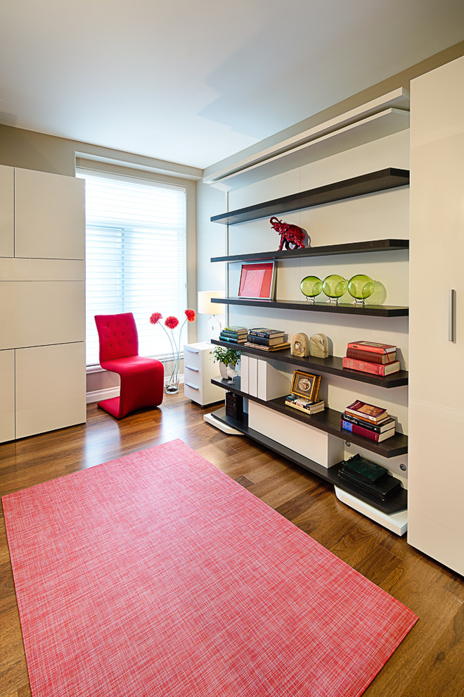 Imagen de habitación de invitados minimalista pequeña sin chimenea con paredes beige y suelo de madera en tonos medios