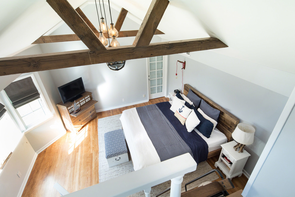 Foto de dormitorio tipo loft marinero pequeño sin chimenea con paredes grises y suelo de madera en tonos medios
