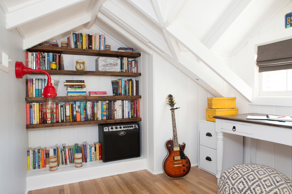 Imagen de dormitorio principal costero pequeño sin chimenea con paredes grises y suelo de madera en tonos medios