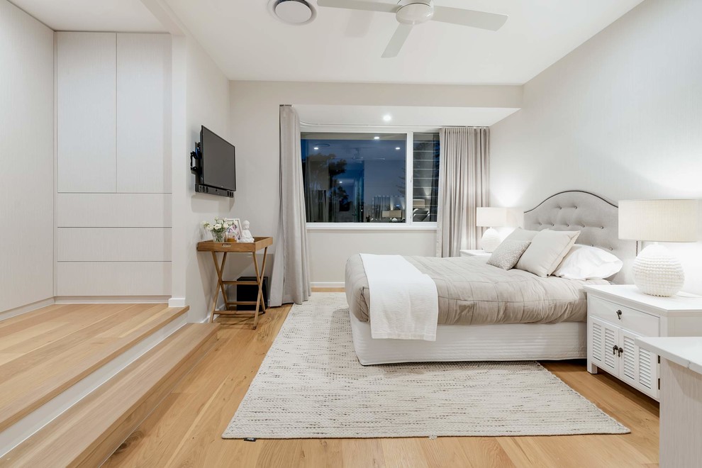 Esempio di una camera degli ospiti stile marino di medie dimensioni con pareti bianche, pavimento in legno massello medio e pavimento marrone