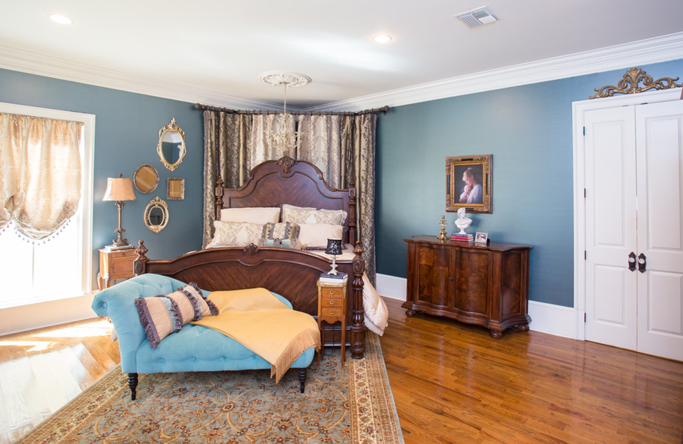 Esempio di una camera matrimoniale vittoriana con pareti blu e pavimento in legno massello medio