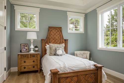 Benjamin Moore Beach Glass painted walls in a bedroom with bright white trim, and wood furniture.