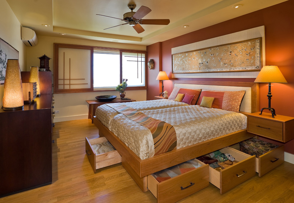 Asiatisches Schlafzimmer mit oranger Wandfarbe und braunem Holzboden in Hawaii