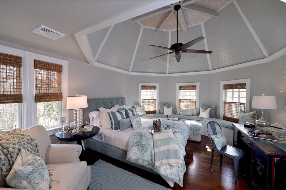 Imagen de habitación de invitados costera grande con paredes grises y suelo de madera en tonos medios