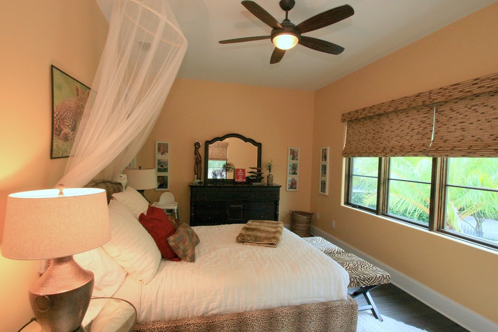 タンパにある中くらいなトラディショナルスタイルのおしゃれな客用寝室 (オレンジの壁、濃色無垢フローリング、暖炉なし、茶色い床)