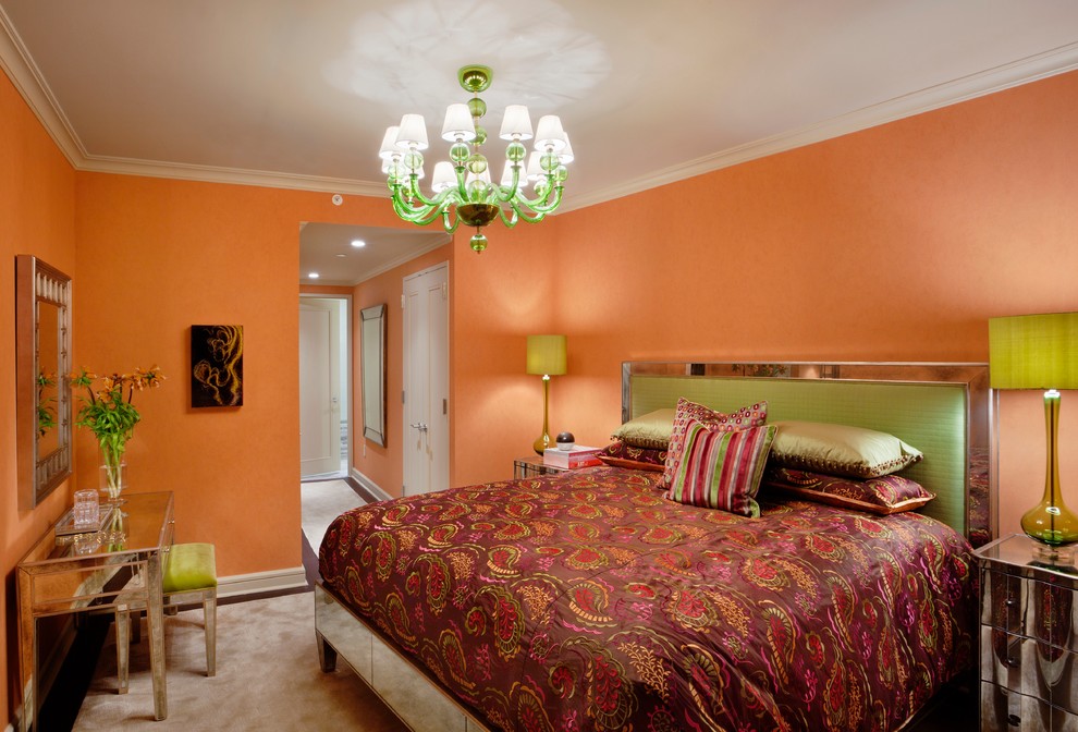 Large bohemian master bedroom in Houston with orange walls, carpet and no fireplace.
