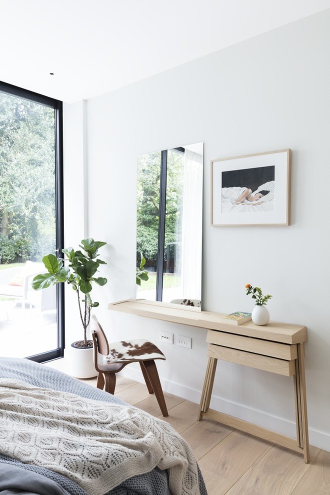 Foto di una camera da letto minimal con pareti grigie e parquet chiaro