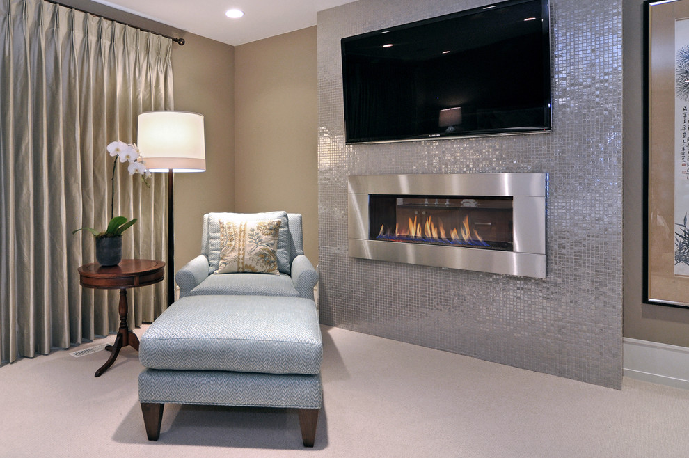 This is an example of a traditional bedroom in Calgary with a ribbon fireplace and a metal fireplace surround.