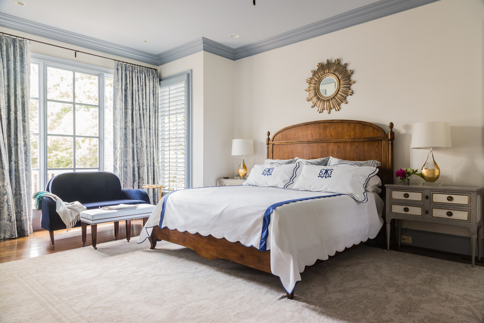Modelo de dormitorio principal clásico de tamaño medio sin chimenea con suelo de madera en tonos medios y paredes blancas