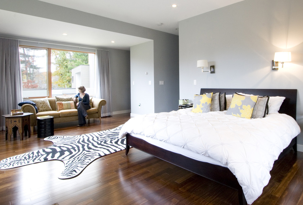 Modelo de dormitorio contemporáneo con paredes grises y suelo de madera oscura