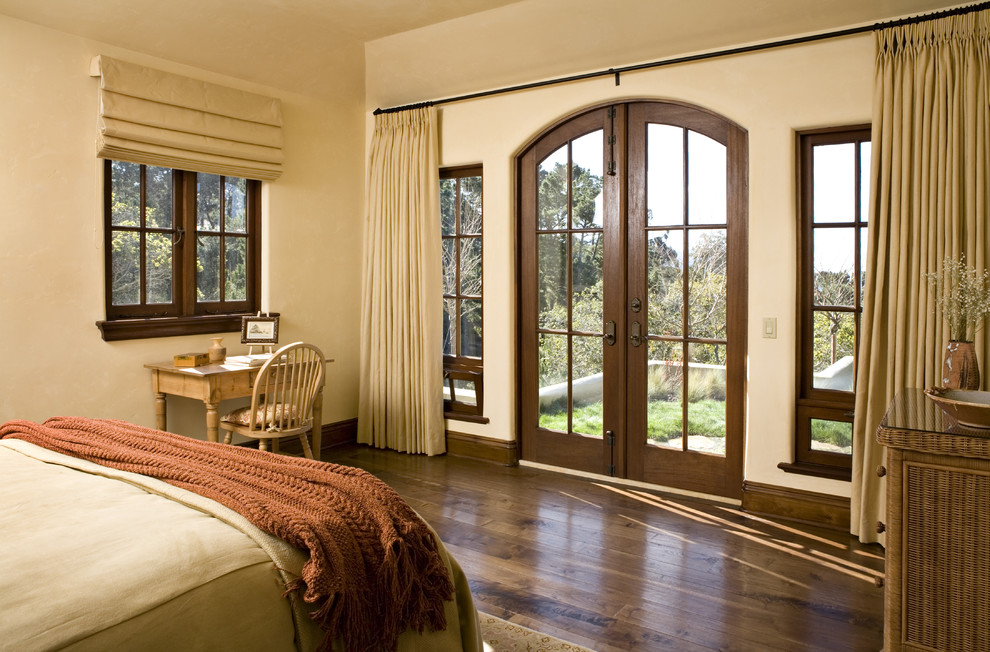 Mediterranes Schlafzimmer mit beiger Wandfarbe und dunklem Holzboden in Sonstige