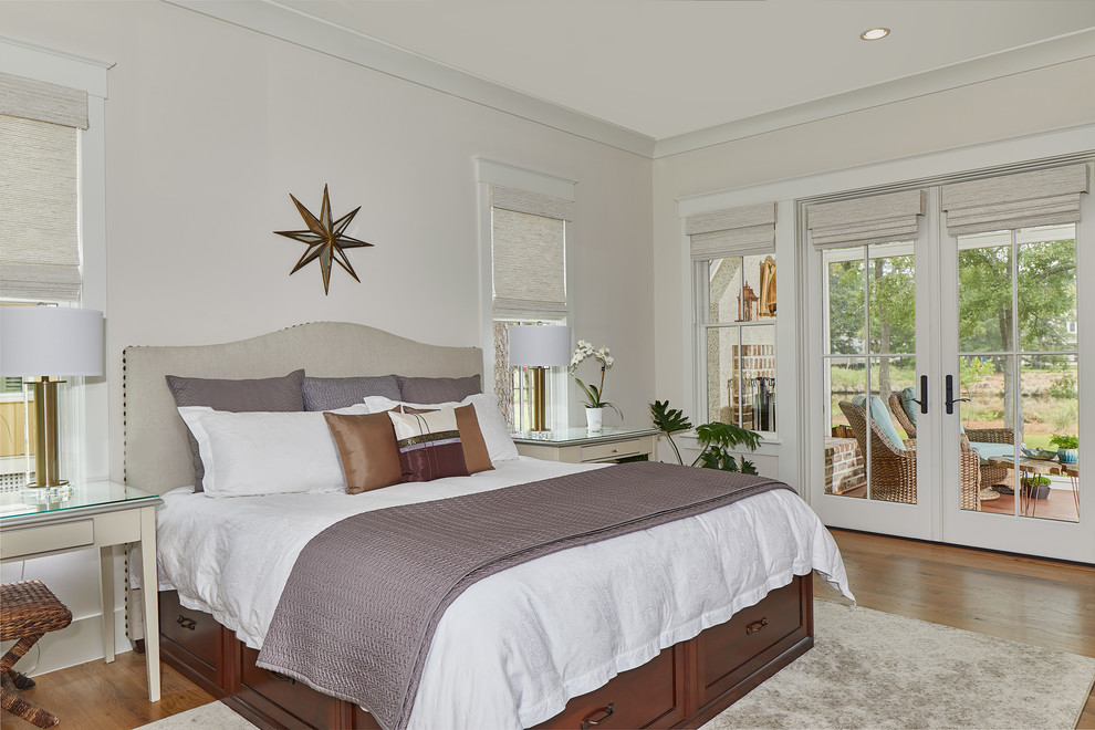 Mittelgroßes Maritimes Hauptschlafzimmer ohne Kamin mit beiger Wandfarbe, braunem Holzboden und braunem Boden in Charleston
