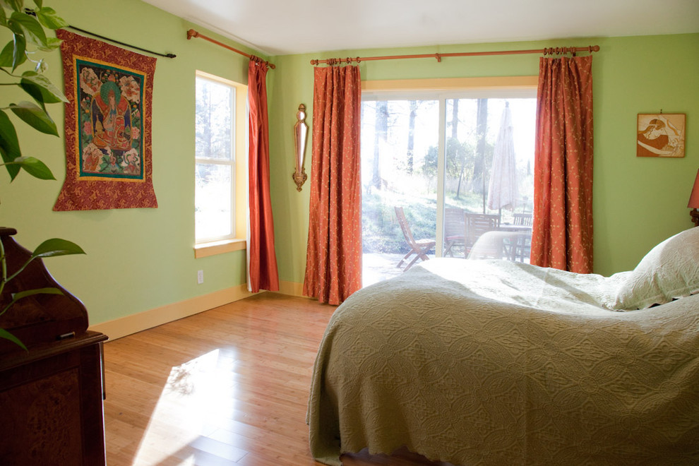 Modelo de dormitorio principal ecléctico de tamaño medio con paredes verdes y suelo de bambú