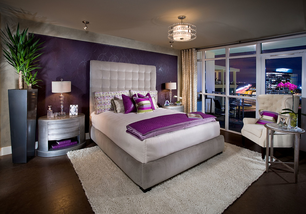 Exemple d'une grande chambre parentale tendance avec un mur violet, parquet foncé, aucune cheminée et un sol marron.