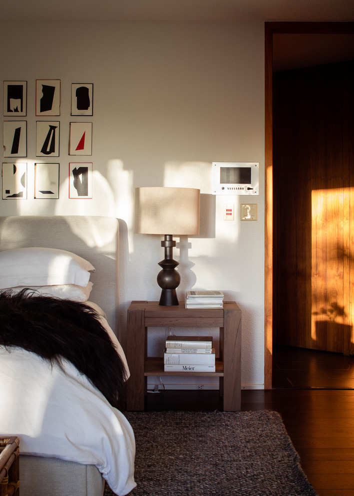 Стильный дизайн: спальня в стиле ретро с белыми стенами, темным паркетным полом и коричневым полом - последний тренд