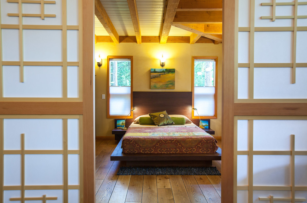 Foto de habitación de invitados actual con suelo de madera en tonos medios y vigas vistas