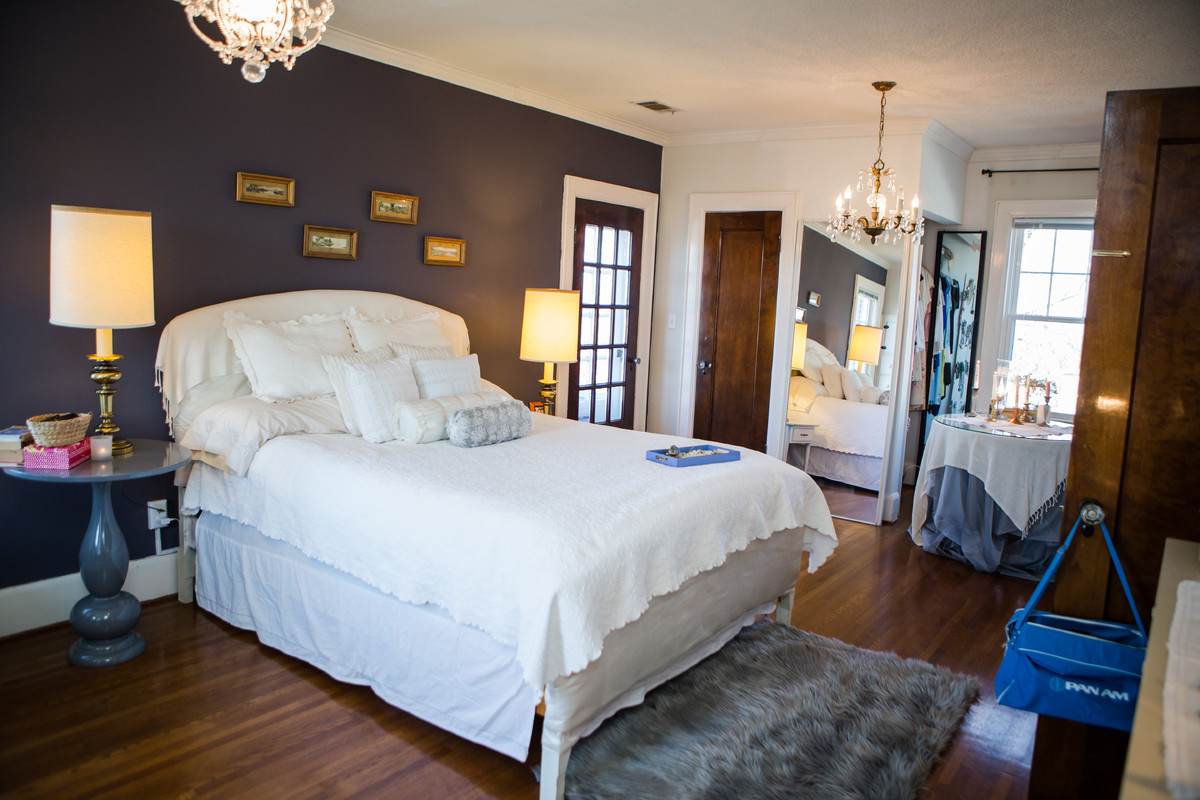 Großes Klassisches Hauptschlafzimmer mit lila Wandfarbe, weißem Boden und braunem Holzboden in Sonstige