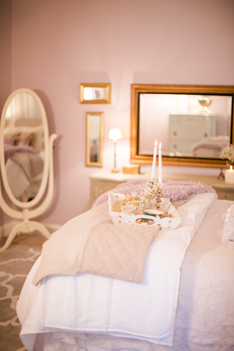 Exemple d'une grande chambre romantique avec un mur rose, cheminée suspendue, un manteau de cheminée en métal et un sol rose.