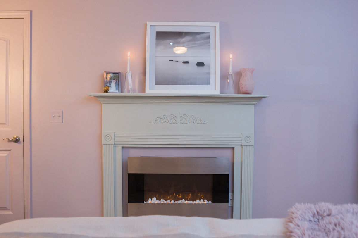 Großes Shabby-Look Hauptschlafzimmer mit rosa Wandfarbe, Teppichboden, Hängekamin, Kaminumrandung aus Metall und rosa Boden in Sonstige