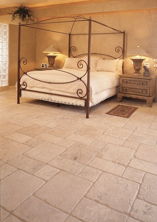 Idée de décoration pour une grande chambre parentale chalet avec un mur beige et un sol en travertin.
