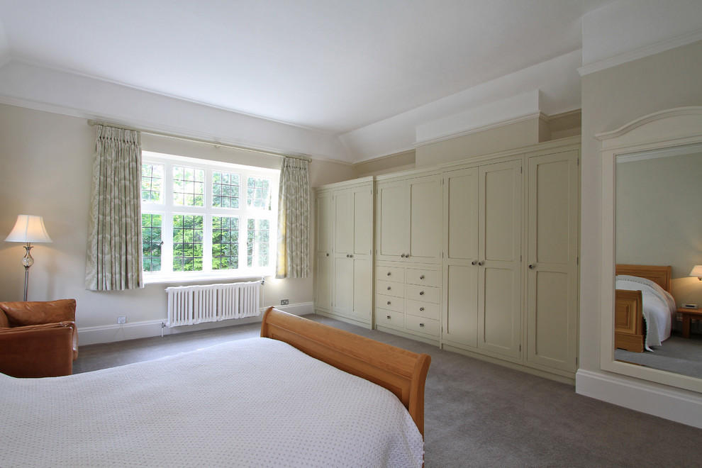 Imagen de dormitorio principal clásico grande sin chimenea con paredes beige y moqueta