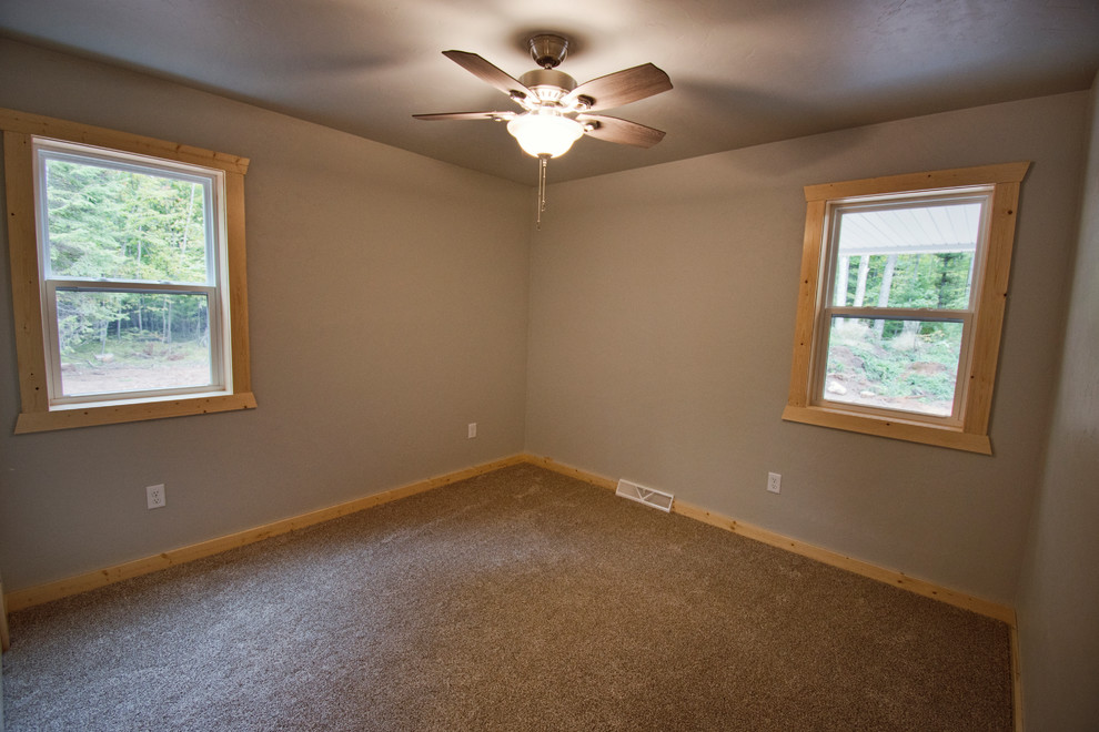 Modelo de habitación de invitados rústica de tamaño medio con paredes beige, moqueta y suelo marrón