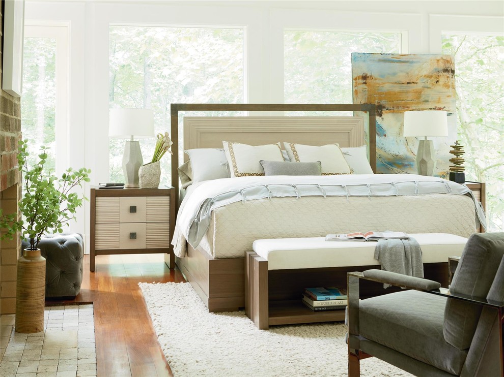 Exemple d'une grande chambre parentale tendance avec un mur blanc, un sol en bois brun, une cheminée standard, un manteau de cheminée en brique et un sol marron.