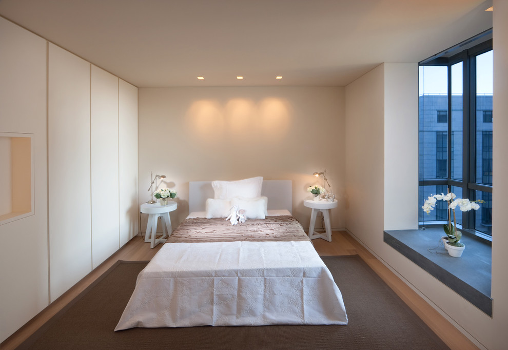 На фото: спальня в современном стиле с бежевыми стенами и светлым паркетным полом с