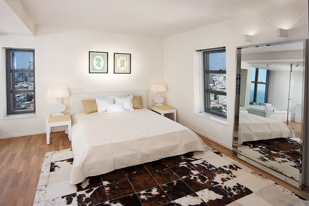 他の地域にあるコンテンポラリースタイルのおしゃれな寝室 (白い壁、淡色無垢フローリング、ベッド下のラグ)