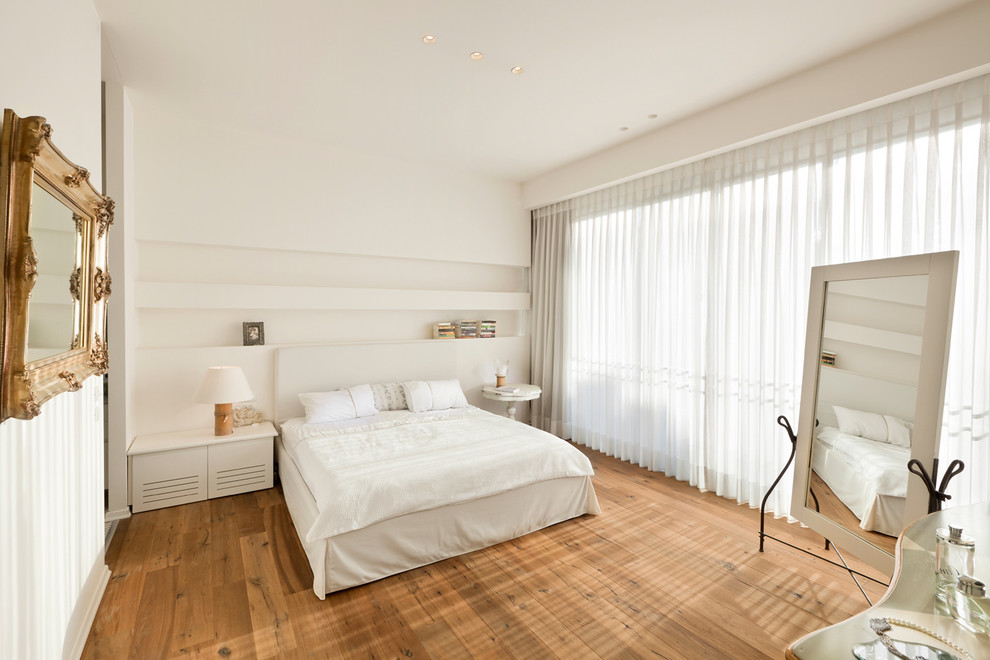 Idée de décoration pour une chambre tradition avec un mur blanc et un sol en bois brun.